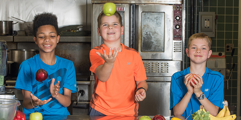 3 boys juggle different types of apples