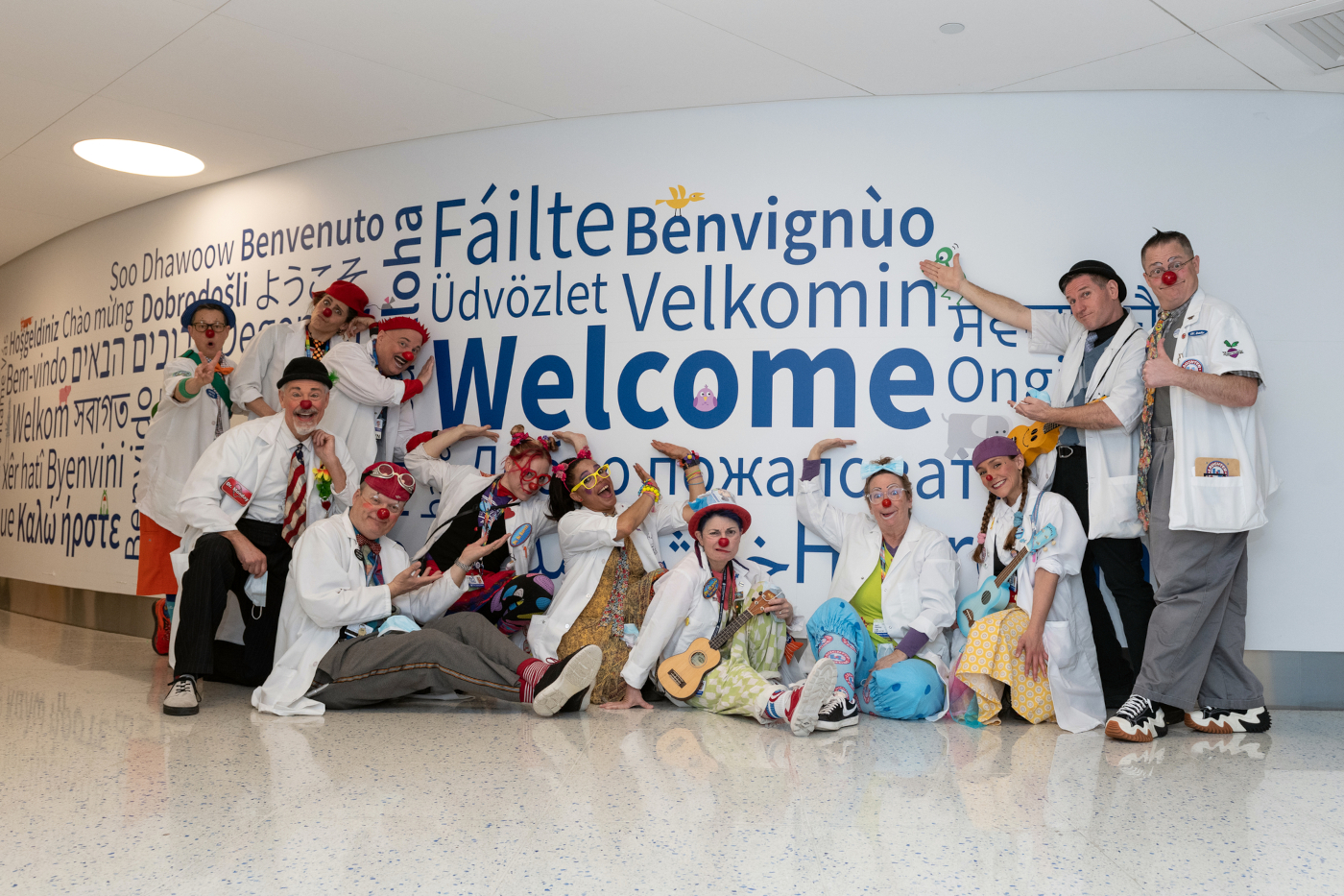 Men and women dressed as clowns pose for camera in hallway at Boston Children's