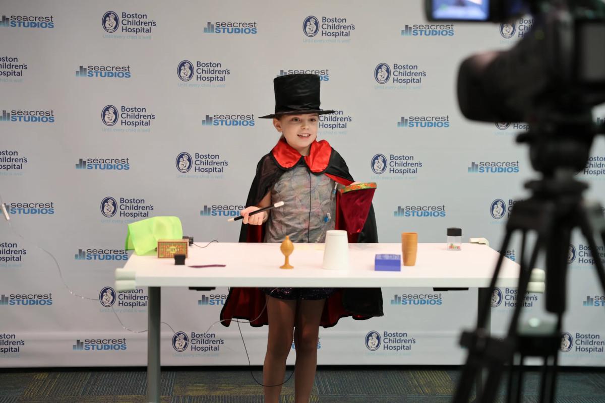 Boy wearing top hat and costume poses in front of Seacrest Studios camera