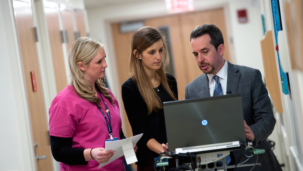 Clinicians look at medical data on laptop