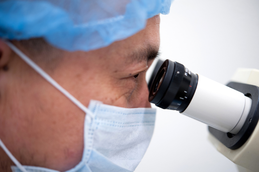 Medical researcher peers into microscope