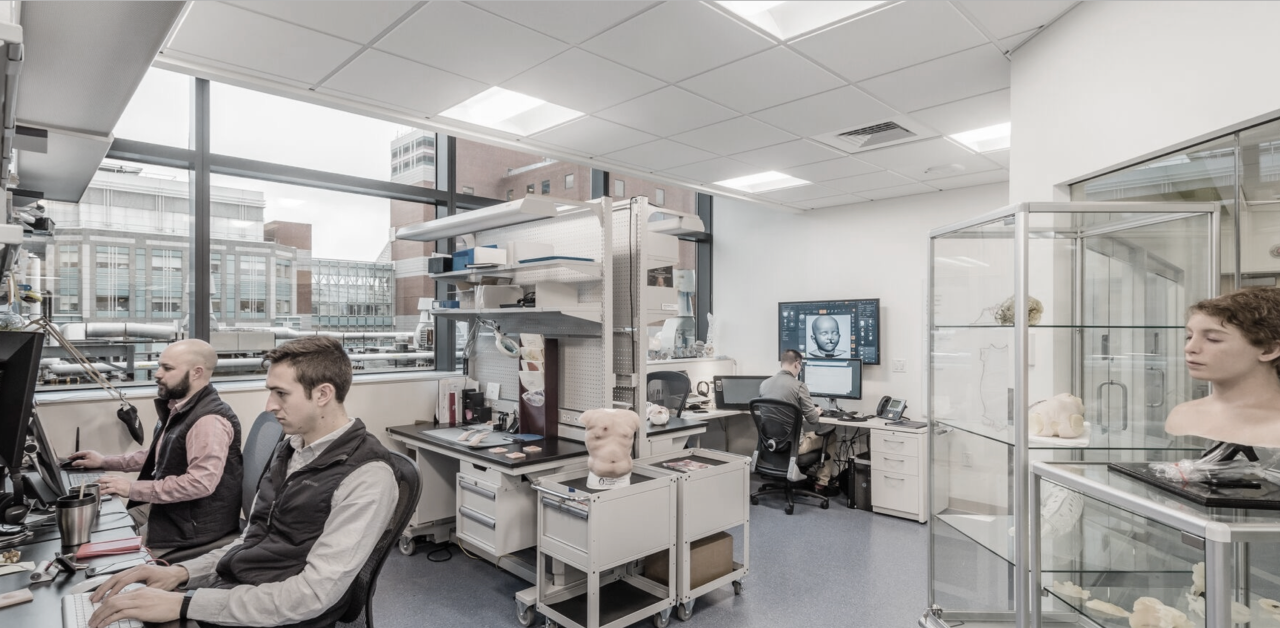 Two men sit at computers in the engineering room for Immersive Design Systems.