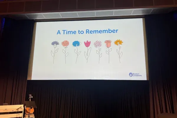 Words on big screen entering memorial service: ‘A Time to Remember,’ with illustration of various flowers