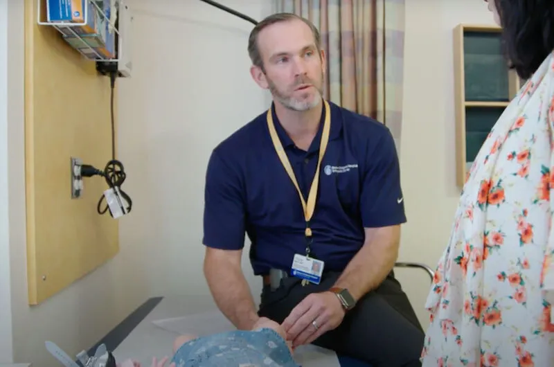 Dr. Collin May talks with a young patient's mother.