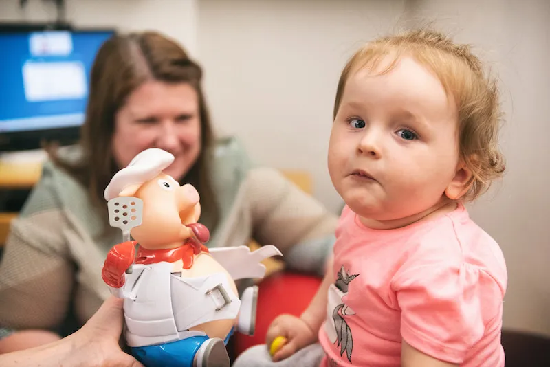 Young girl wearing pink shirt stares at camera